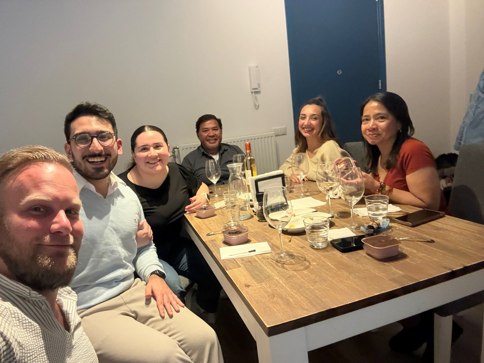 Guests smiling around a home dinner table