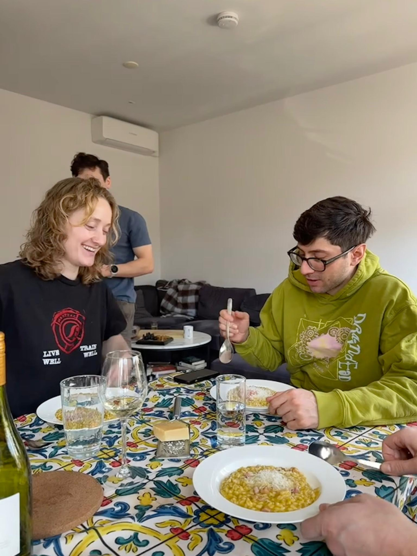 Friends sharing a home-cooked risotto around a tiled dinner table
